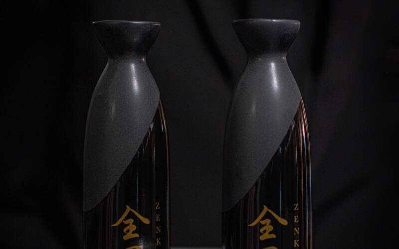 A team member at The George presents two Wakatipu Sleeping Giant Junmai Ginjo served in traditional tokkuri (pitchers) at the 2025 Sakura and Sake Dinner hosted in one of the private dining venues at The George